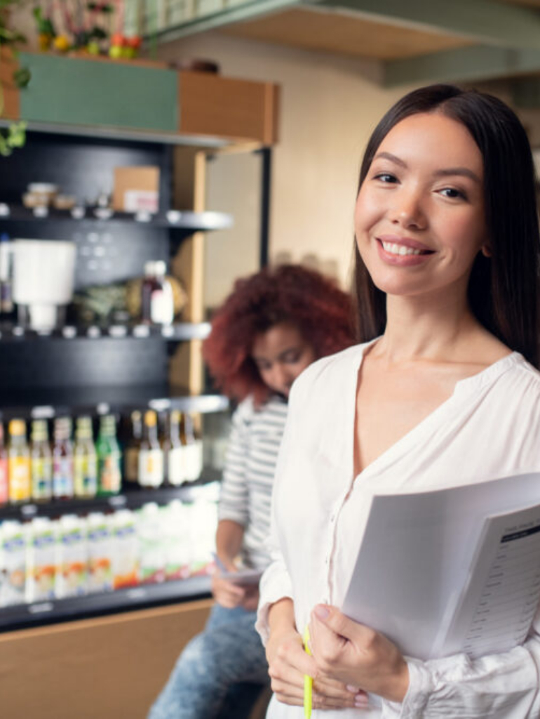 Woman owning cafeteria. Young dark-haired woman owning cafeteria standing and holding documents